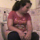 A brunette girl with a big bottom tells us how much she loves to eat beans. She proceeds to eat her bowl of beans while sitting on a toilet. Some bodily functions are audible, so we assume she pooped. No poop is actually seen. Over 4 minutes.